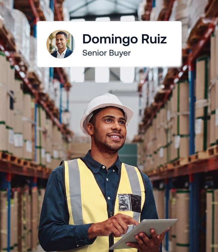 Senior buyer Domingo Ruiz holding a digital tablet inside a large logistics warehouse facility